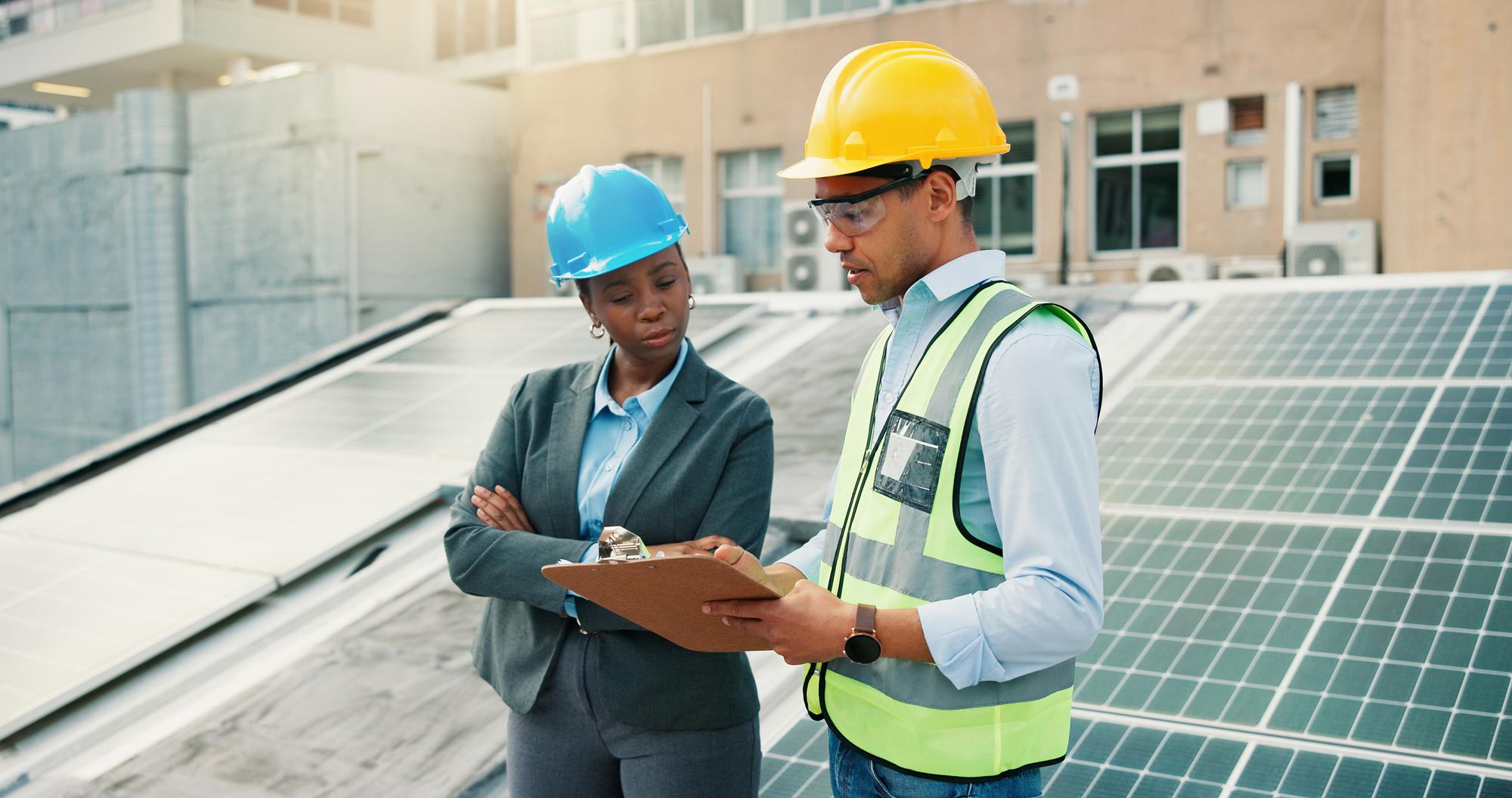 Clipboard planning and solar energy with construction worker people on building roof for inspection Architecture collaboration or conversation with team outdoor to install photovoltaic panels