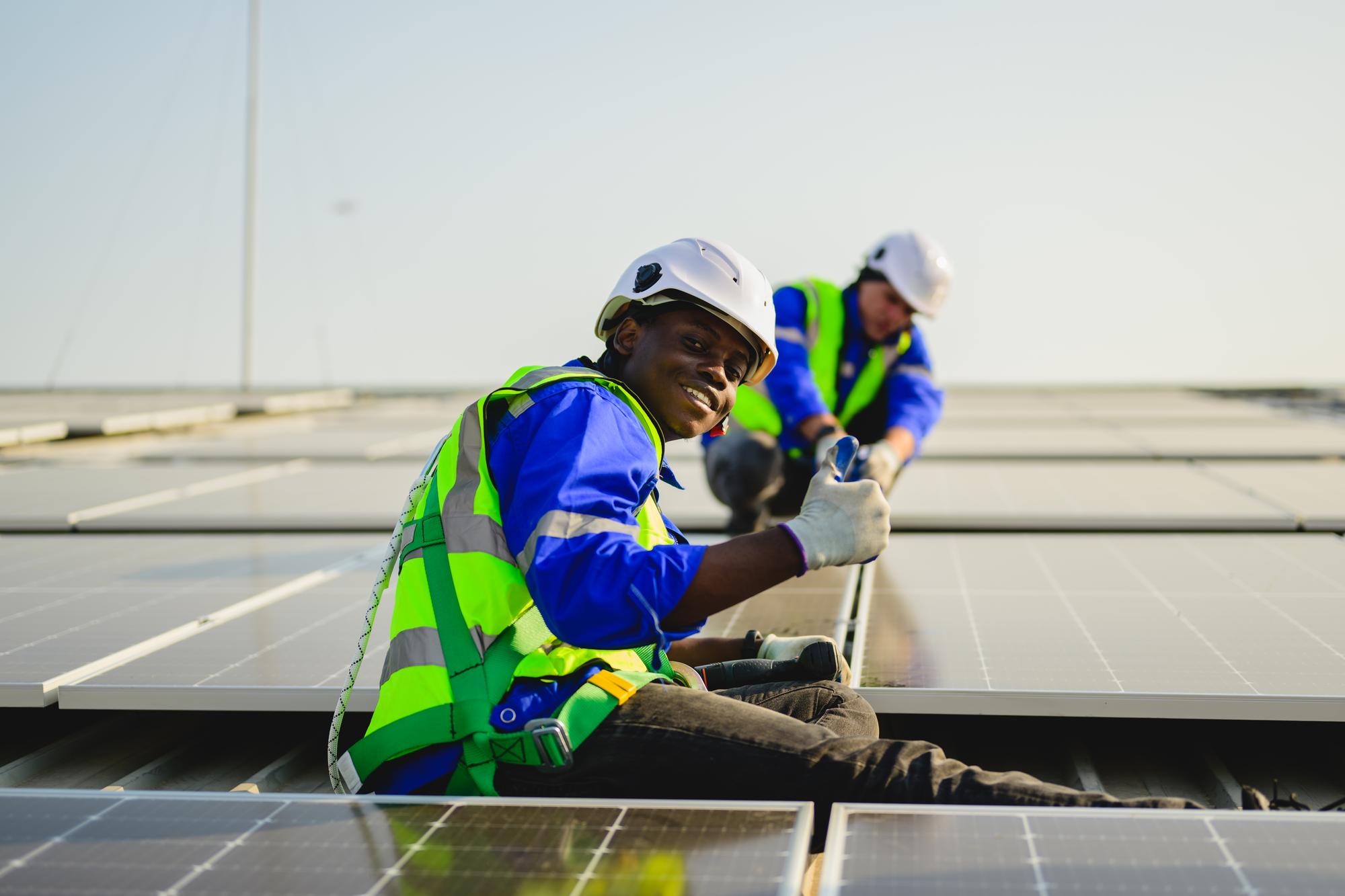 Maintenance technicians installing solar panels at solar cell farm